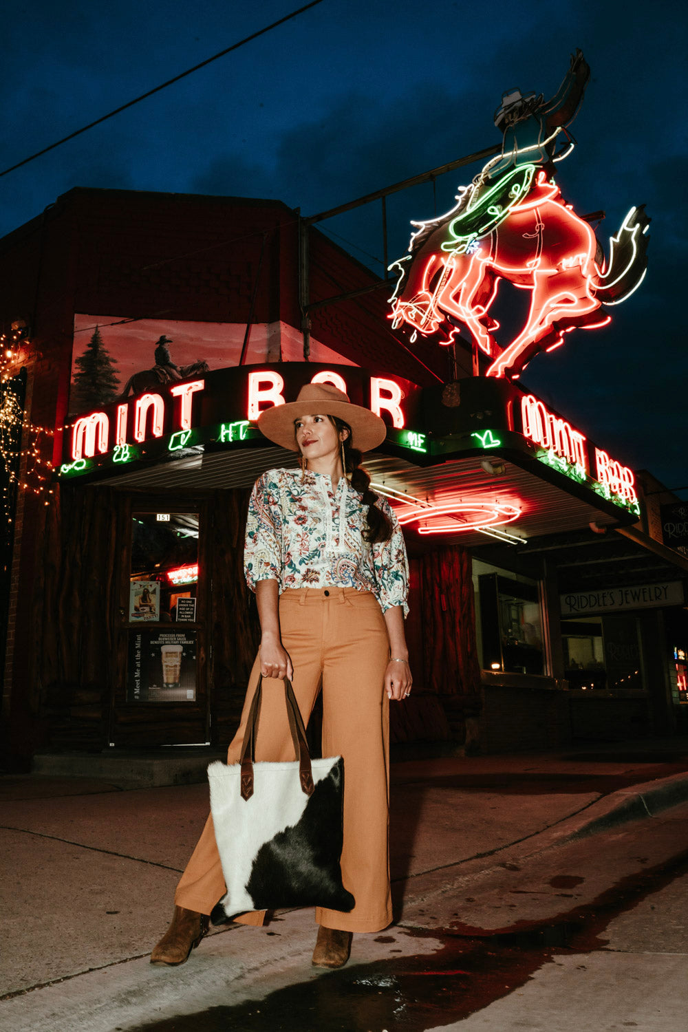 Women in front of mint bar with cowhide purse