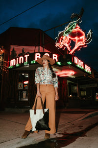 Thumbnail for Women in front of mint bar with cowhide purse