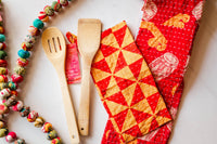 Thumbnail for Wooden utensils and colorful fabric with geometric patterns on a light background