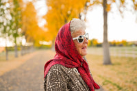 Thumbnail for Mature Woman wearing a red headscarf and sunglasses in an autumn park.