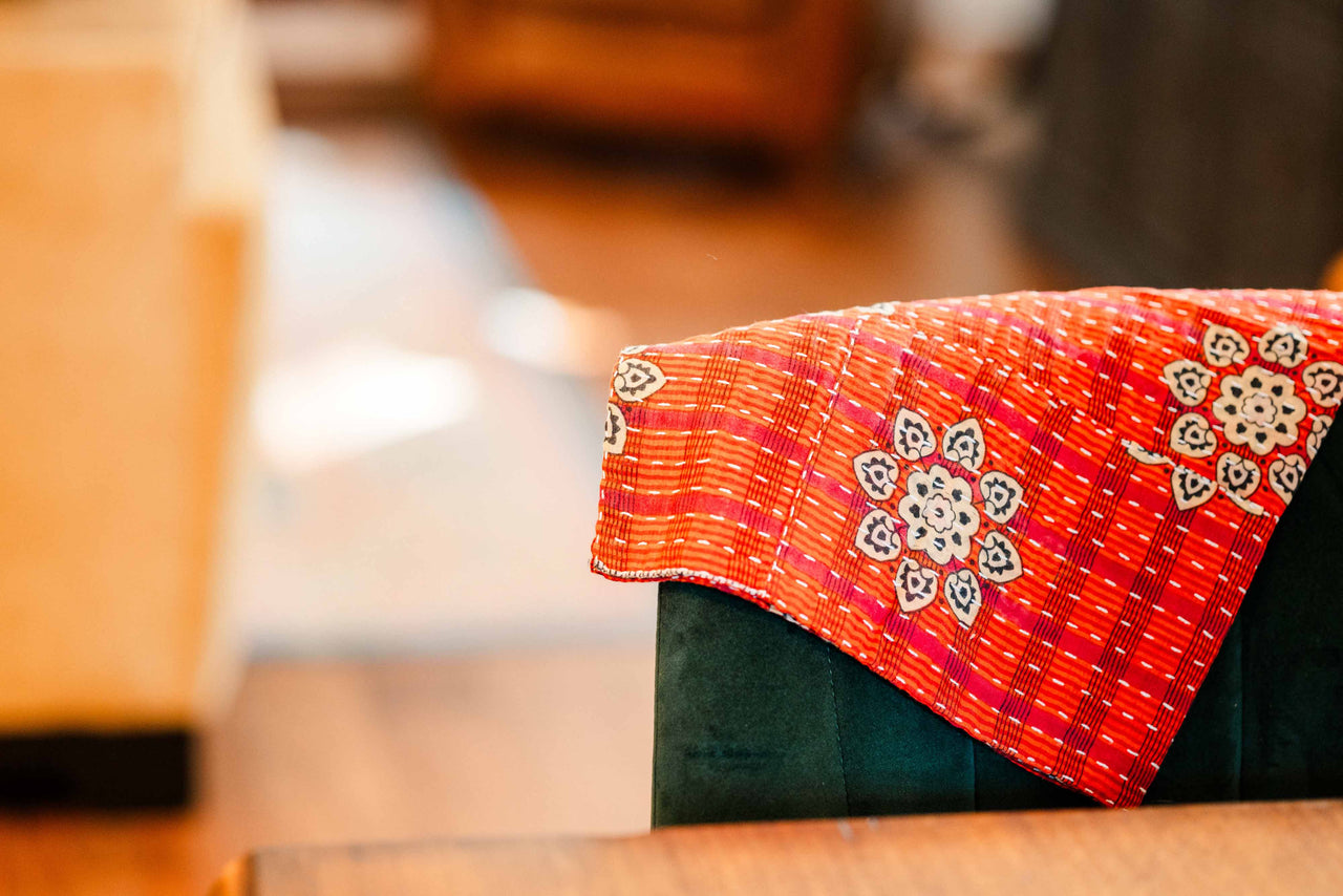 Close-up of a red kantha fabric with a blurred background